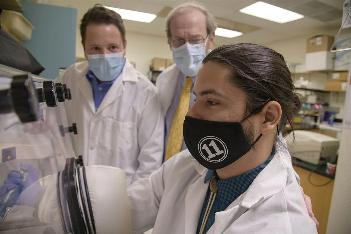 Doctoral student Corbin Jensen (right) alongside mentors Drs. Noel Warfel and Andrew Kraft. Each scholar is expected to conduct original research under the guidance of their chosen mentor-pair, and to participate in clinical cases with their chosen physician mentor.