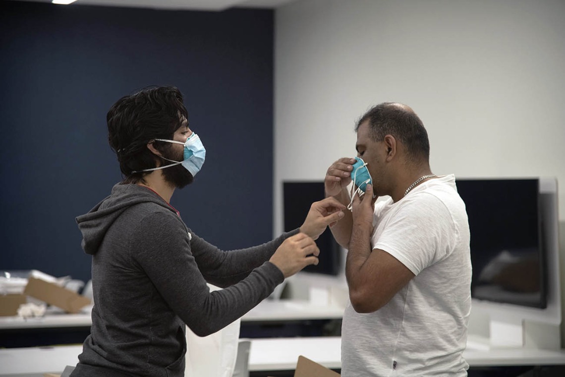 First-year College of Medicine – Tucson student Ahmed Al-Shamari checks second-year student Waheed Asif’s N95 mask to ensure it has a good seal.