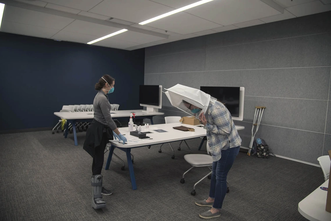 College of Medicine – Tucson student Emerald Montgomery begins a task while wearing the hooded mask with the N95. Afterward, bitters will again be sprayed into the hooded mask. If she can taste them, the equipment is no longer properly fitted.