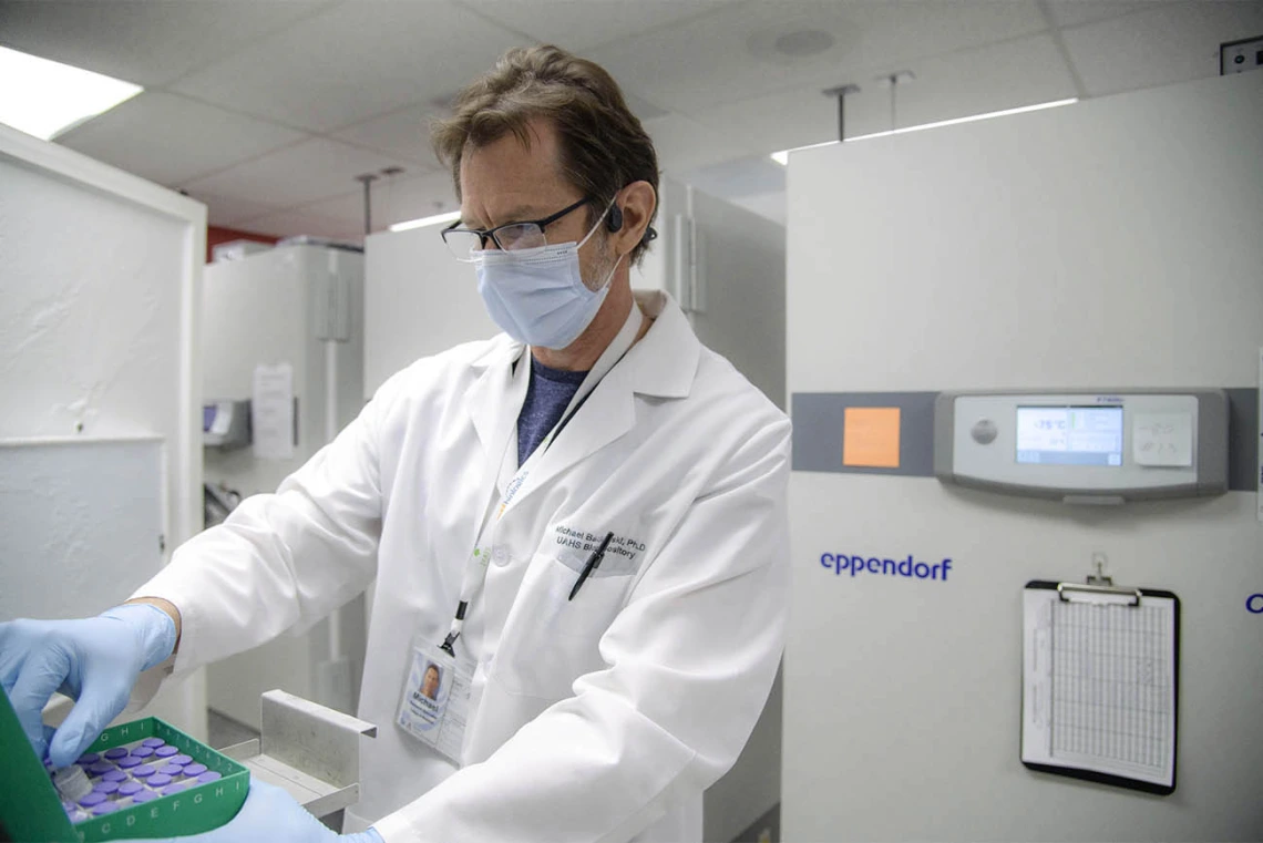 Michael Badowski, PhD, pulls out a vial containing the Pfizer vaccine that will be used at the University POD.