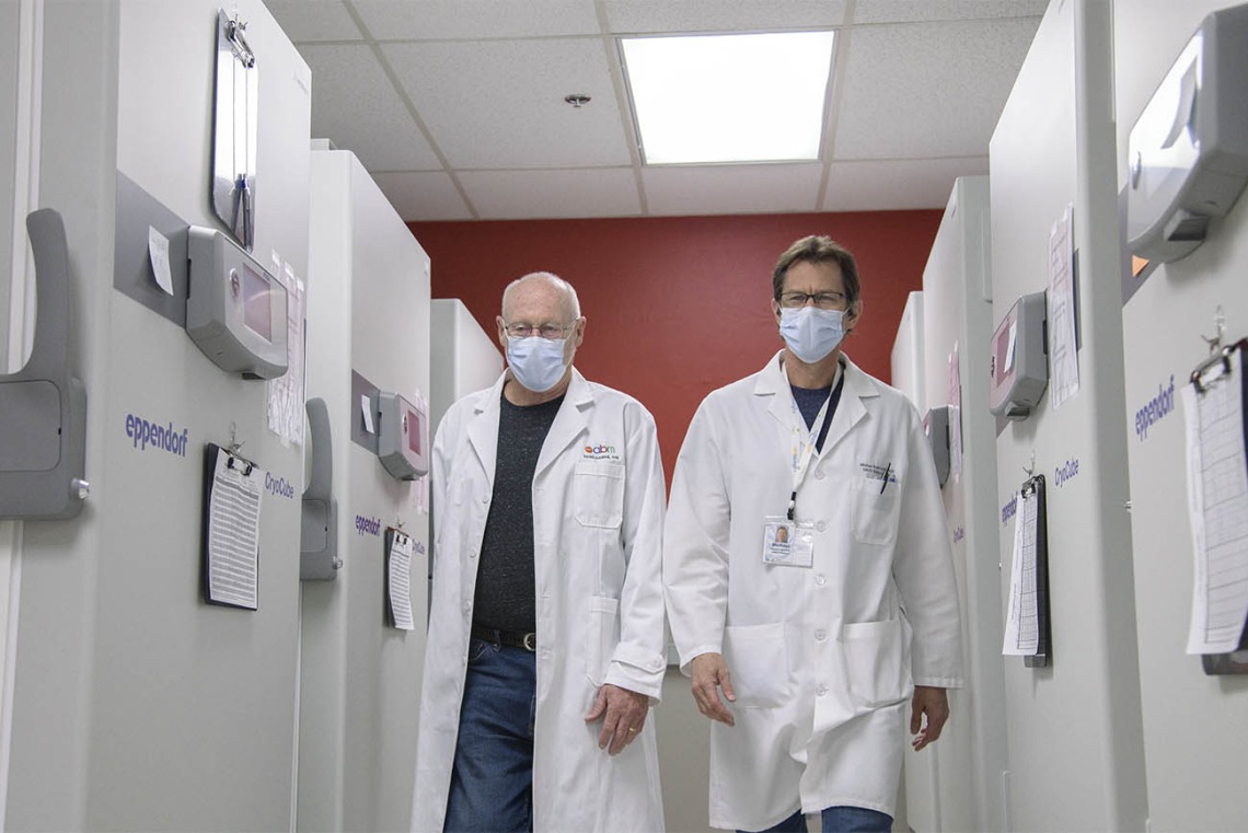 Drs. David Harris and Michael Badowski walk through the freezer farm to collect more vaccines for distribution.