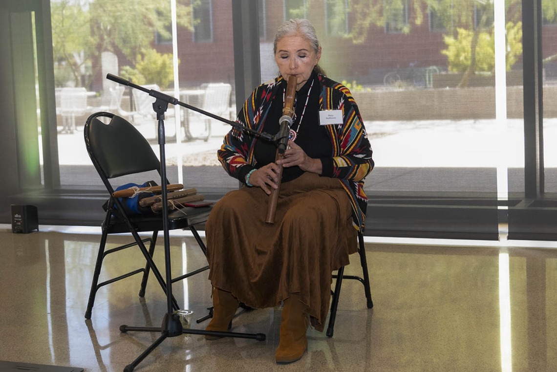 Mary Redhouse plays the American flute inside the Health Science Innovation Building during a reception after the groundbreaking ceremony for the Andrew Weil Center for Integrative Medicine on the University of Arizona Health Sciences campus in Tucson.