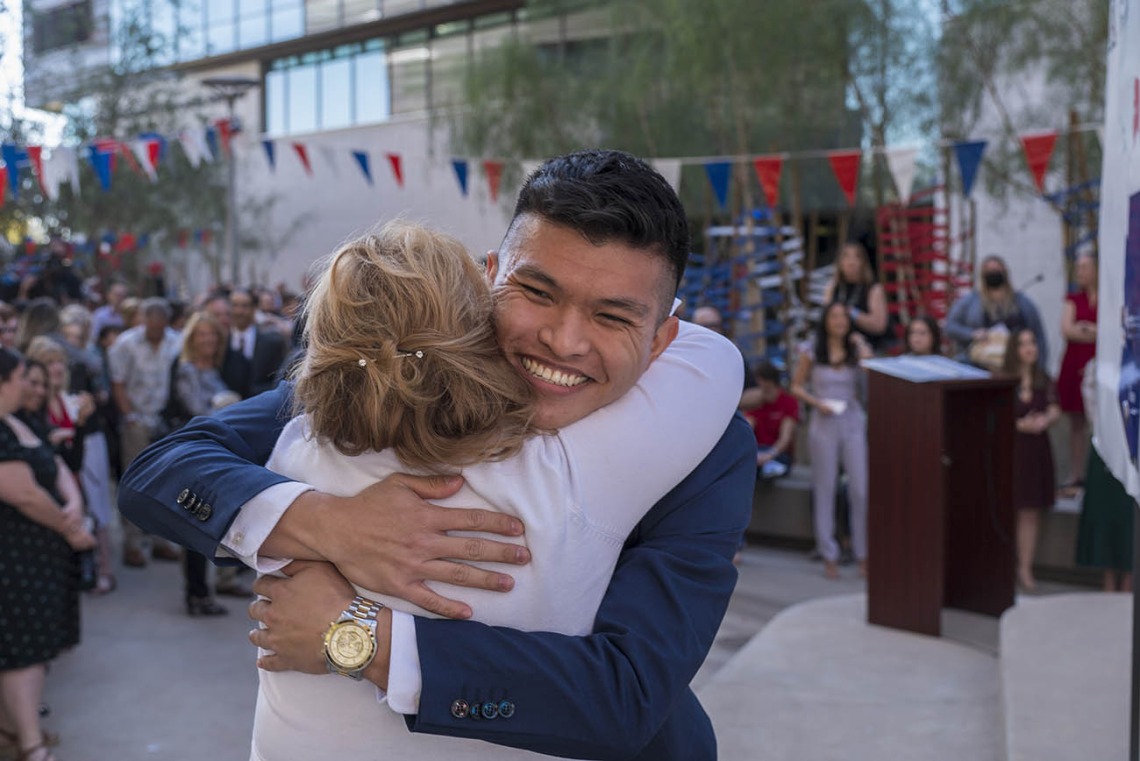 Allen Doan hugs Kelly Lynch, alumni/student relations manager, after being matched during the UArizona College of Medicine – Phoenix Match Day 2022 event.