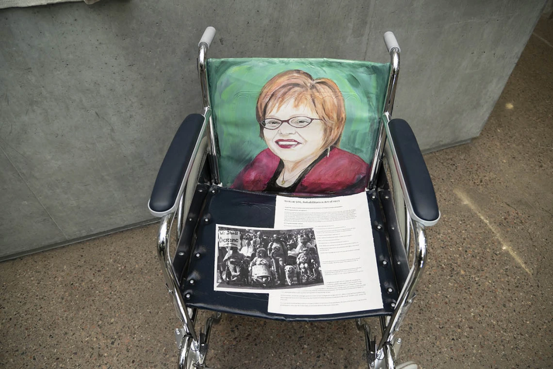 Judy Heumann (1947) — Judy Heumann is a disability advocate who served in both the Clinton and Obama administrations in support of disability rights. She is a co-founder of the World Institute on Disability, one of the first global disability rights organizations founded and led by people with disabilities. Heumann is an internationally recognized leader in the disability rights community. (Acrylics on vinyl with paper, by Suzanne Whitaker)