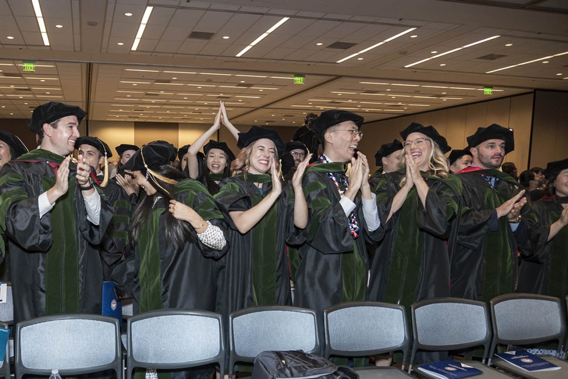Graduates of the UArizona College of Medicine – Phoenix class of 2022 stand and cheer as their commencement ceremony concludes in the Phoenix Convention Center.