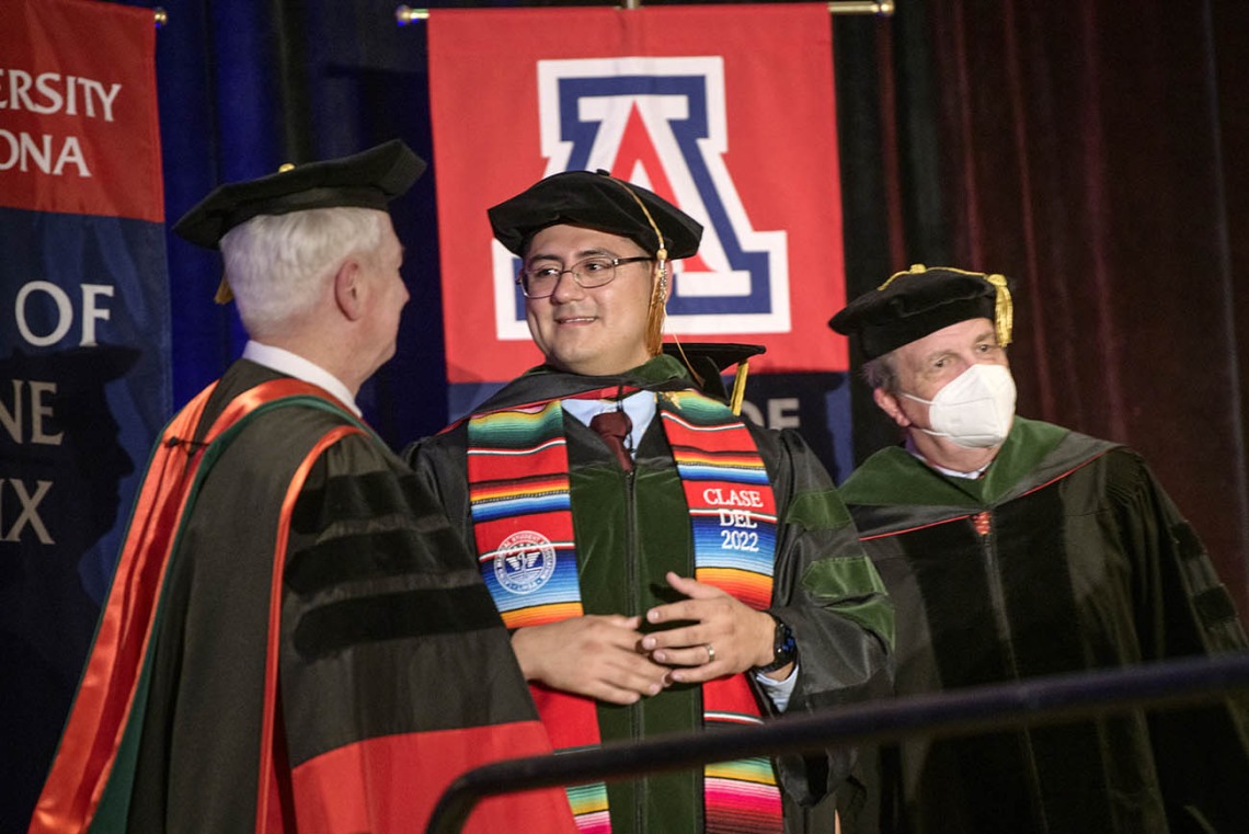 (From left) UArizona College of Medicine – Phoenix Dean Guy Reed, MD, MS, congratulates Jesús Leyva, MD, as they prepare to have a photo taken with Michael D. Dake, MD, senior vice president for Health Sciences at the College of Medicine – Phoenix class of 2022 commencement ceremony.