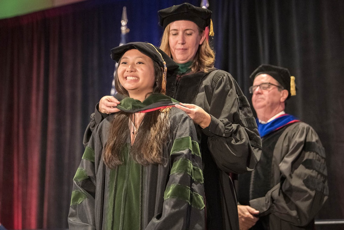 Julie Tran, MD, is hooded by Kathleen Brite Hillis, MD, interim senior associate dean, undergraduate medical education, during the College of Medicine – Phoenix class of 2022 commencement ceremony.
