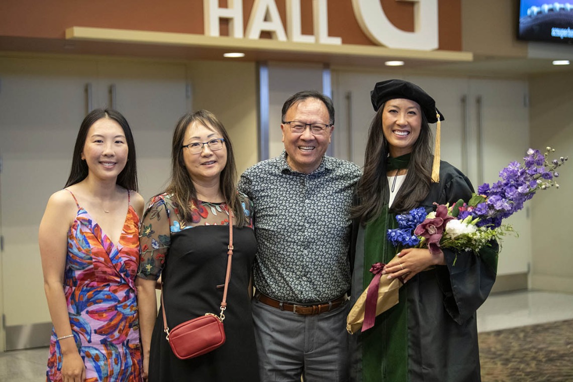 College of Medicine – Phoenix class of 2022 graduate Belle Lin, MD, (right) poses for a photo with her family after her commencement ceremony. Dr. Lin’s family, from left, are sister, Danni Lin, mother, Alice Lin, and father, Jerry Lin.