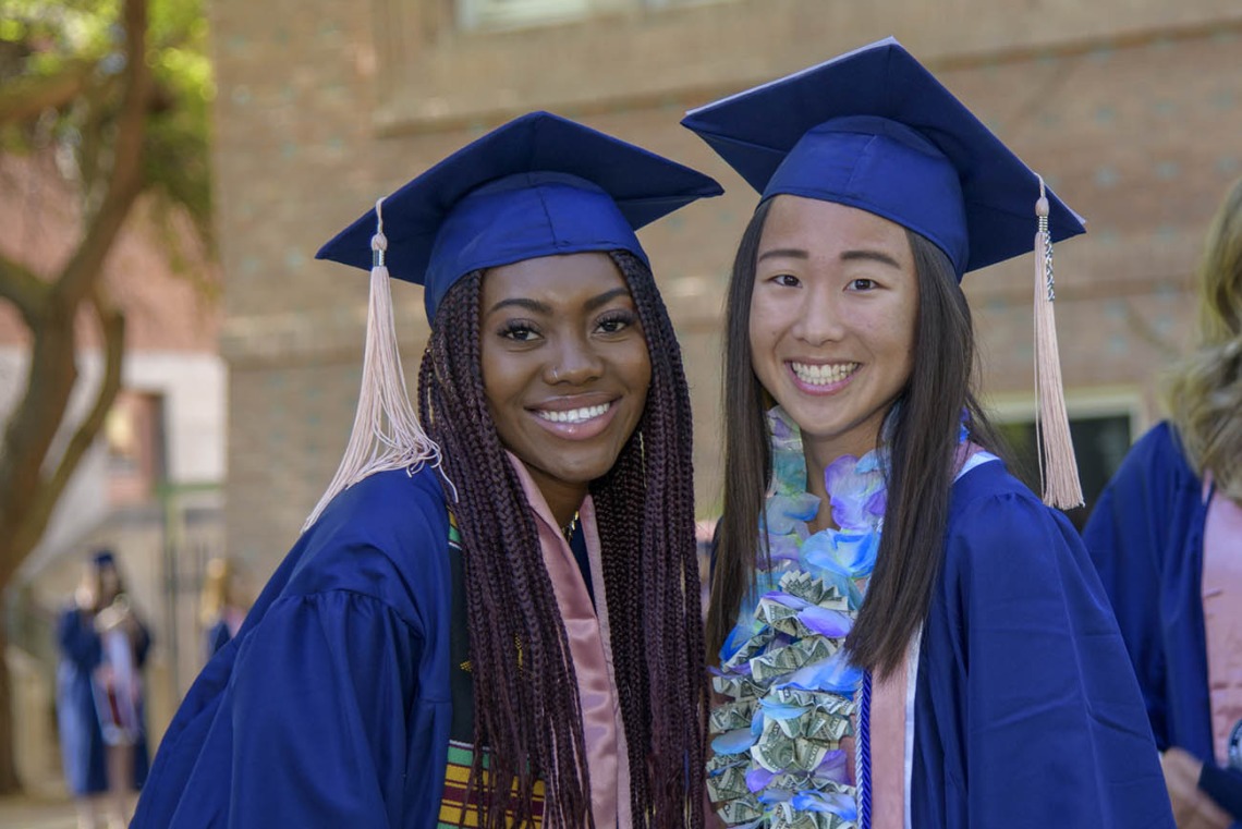 (From left) Jazmin Youngblood and Kara Yagade celebrate the completion of their undergraduate studies at the 2022 Mel and Enid Zuckerman College of Public Health spring convocation.