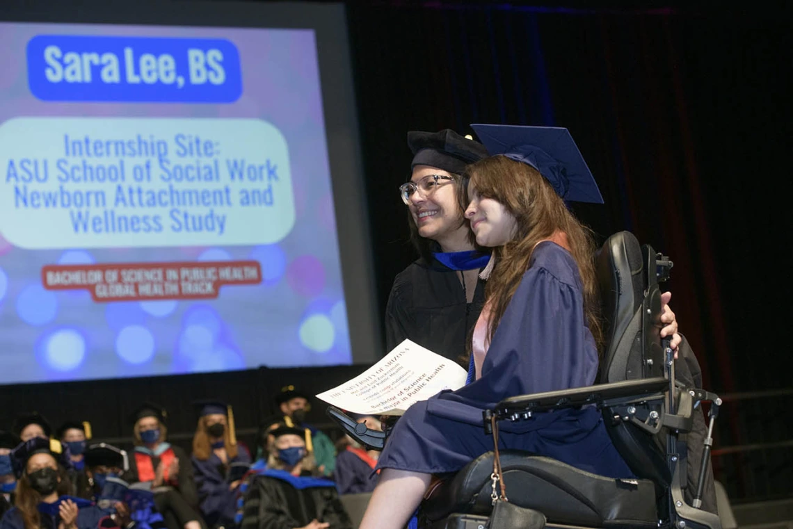 (From left) Gabriela Valdez, PhD, director of global education and global health programs, poses for a photograph with Bachelor of Science graduate Sara Lee as she crosses the stage at Centennial Hall during the 2022 Mel and Enid Zuckerman College of Public Health spring convocation.