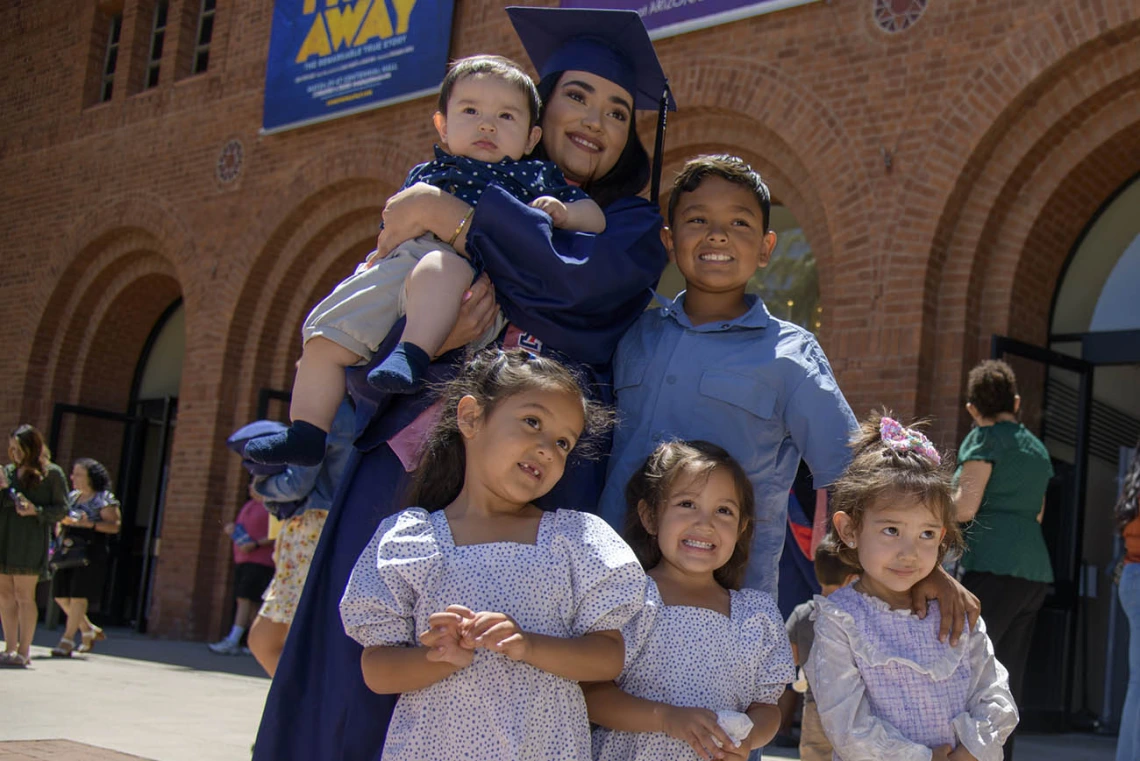 Josselyn Sanchez, MPH, poses with her nephews and nieces outside of Centennial Hall after the 2022 Mel and Enid Zuckerman College of Public Health spring convocation.