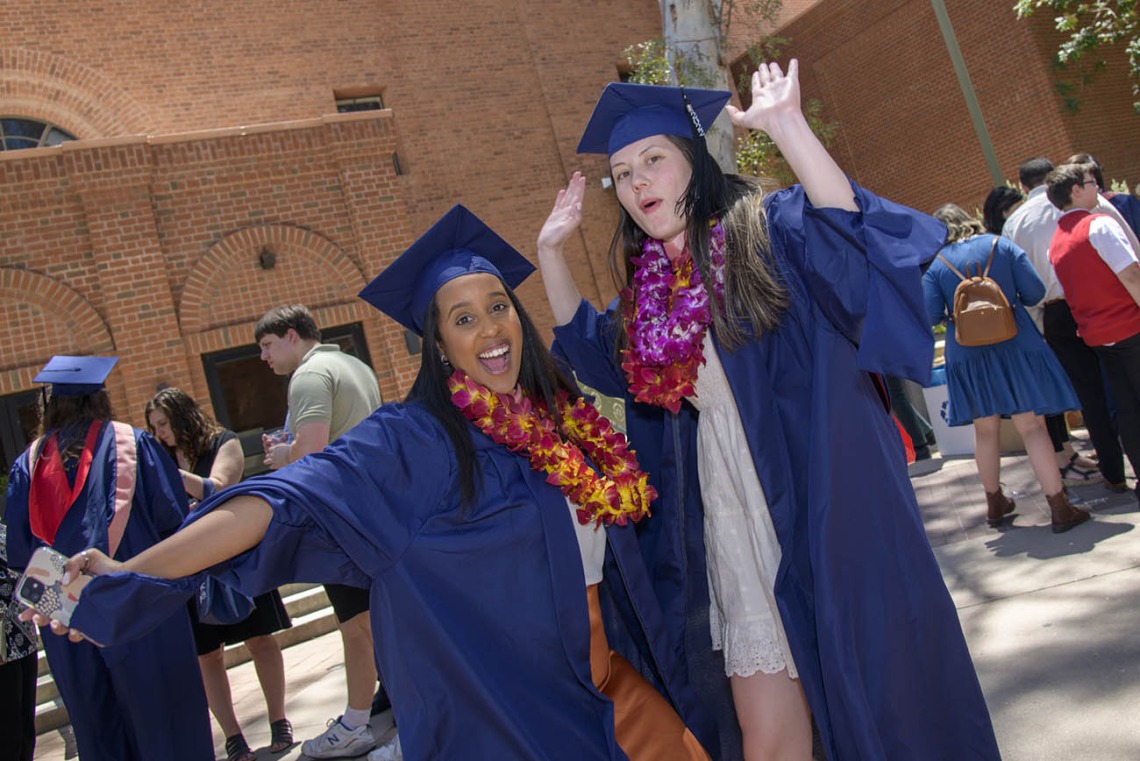 Naomi Abraha, MPH, and Loren Halili, MPH, celebrate after receiving their master’s degrees during the 2022 Mel and Enid Zuckerman College of Public Health spring convocation.