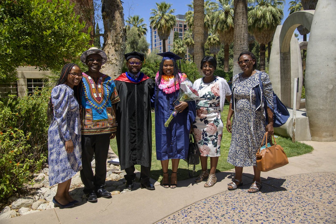 Velma Gesimba, MPH, and her family pose with John Ehiri, PhD, MPH, MSc, associate dean for academic affairs (third from left) after being hooded for earning her Master in Public Health degree during the 2022 spring convocation ceremony for the Mel and Enid Zuckerman College of Public Health.