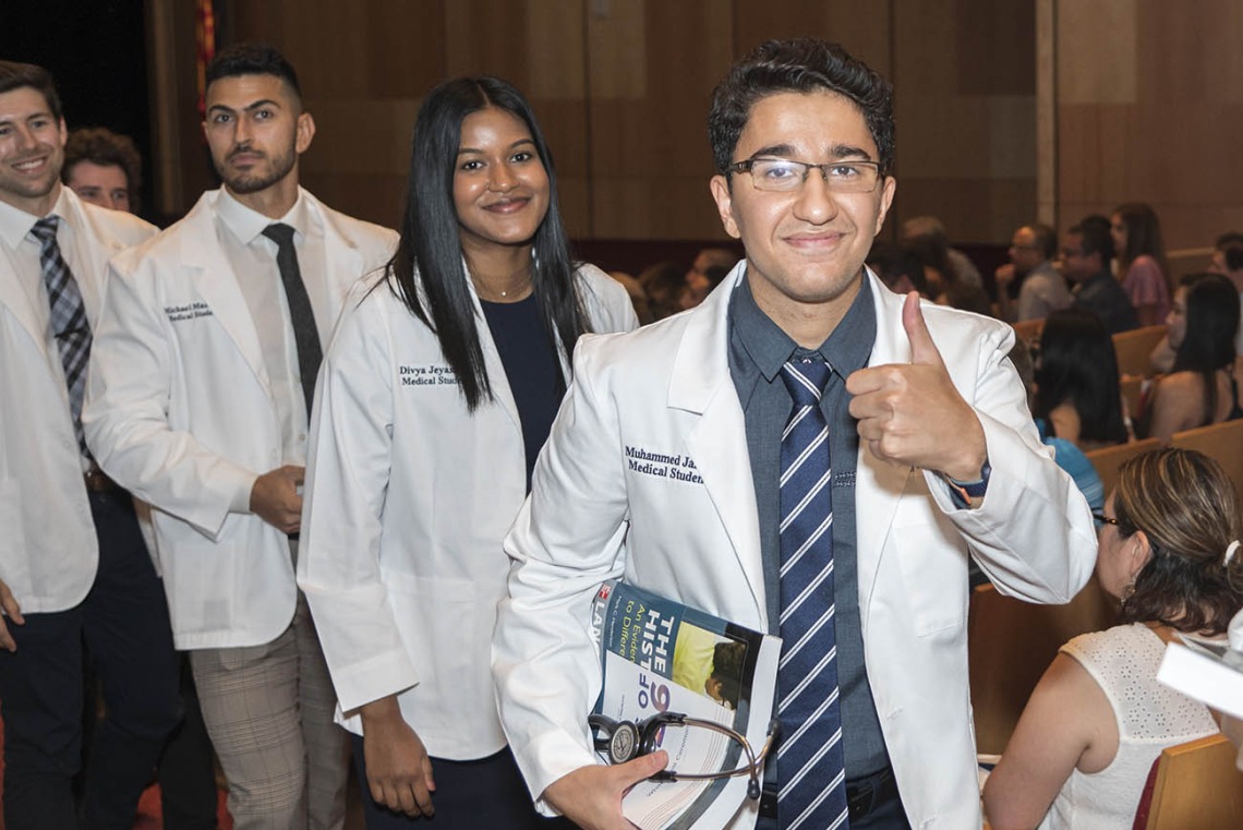 (From right) Muhammed Amir Jaafar, Divya Jeyasingh and Michael Mazarei leave Symphony Hall in a procession after the UArizona College of Medicine – Phoenix Class of 2026 white coat ceremony.