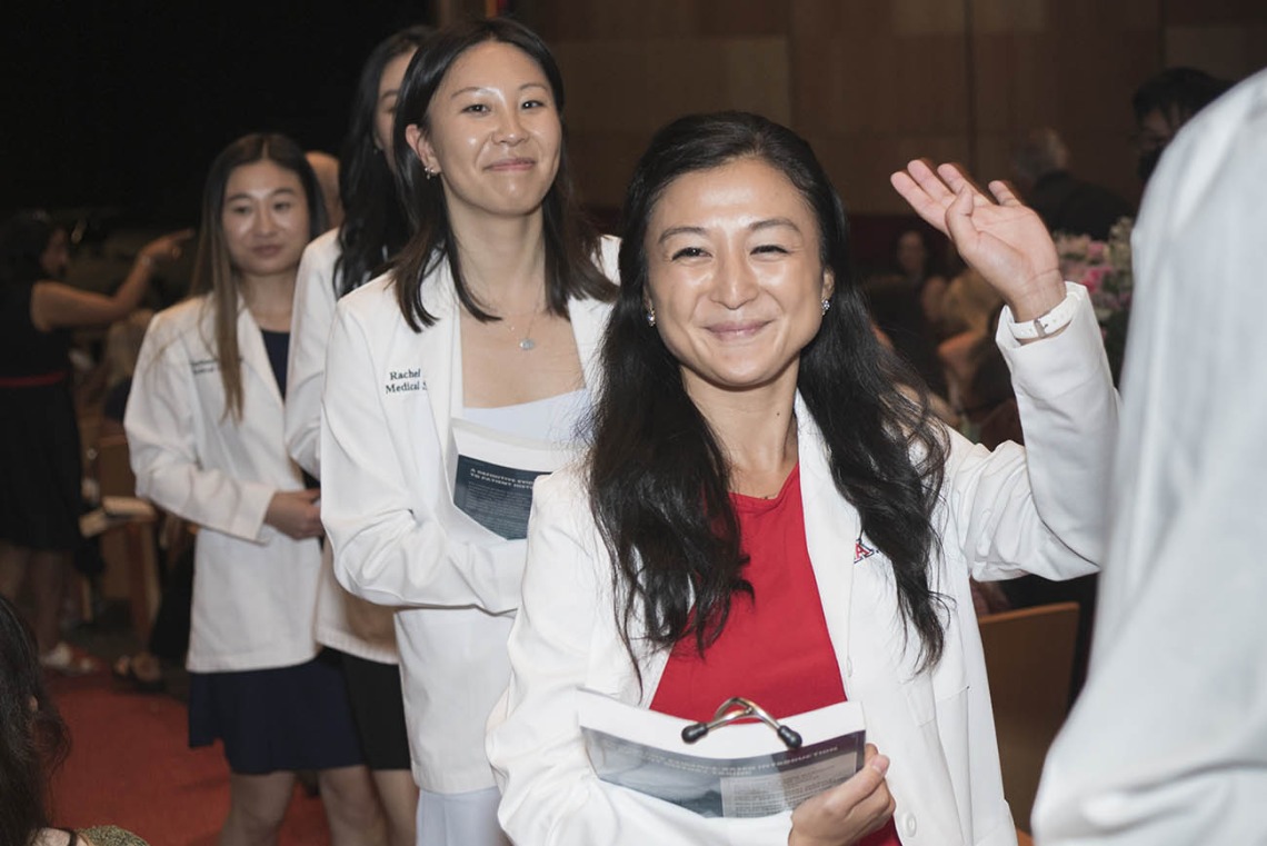 Erika Shiho Yasuda waves to her family as she walks out of Symphony Hall after the UArizona College of Medicine – Phoenix Class of 2026 white coat ceremony in downtown Phoenix.