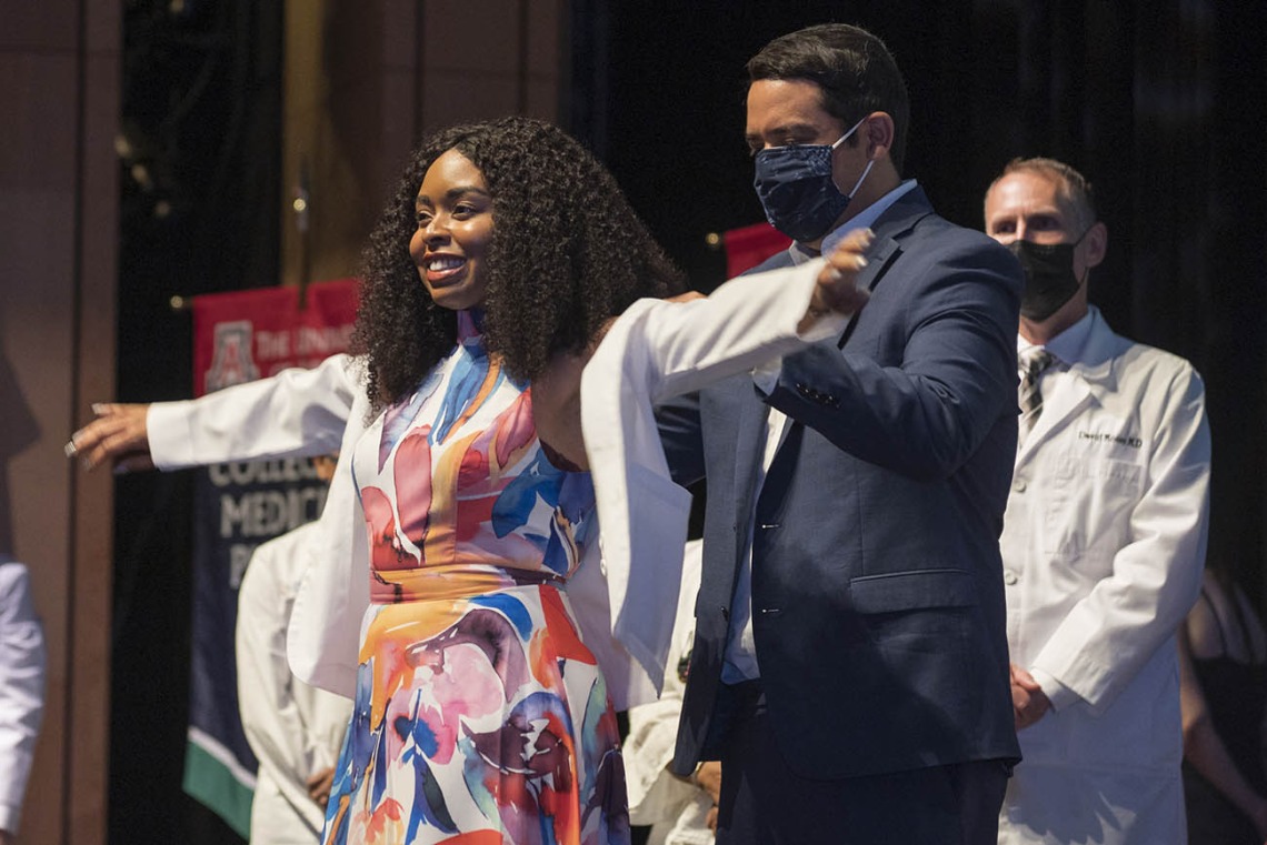 Bre’annca Charell Sanders is presented with her white coat by Francisco Lucio, JD, associate dean of equity, diversity and inclusion for the UArizona College of Medicine – Phoenix.