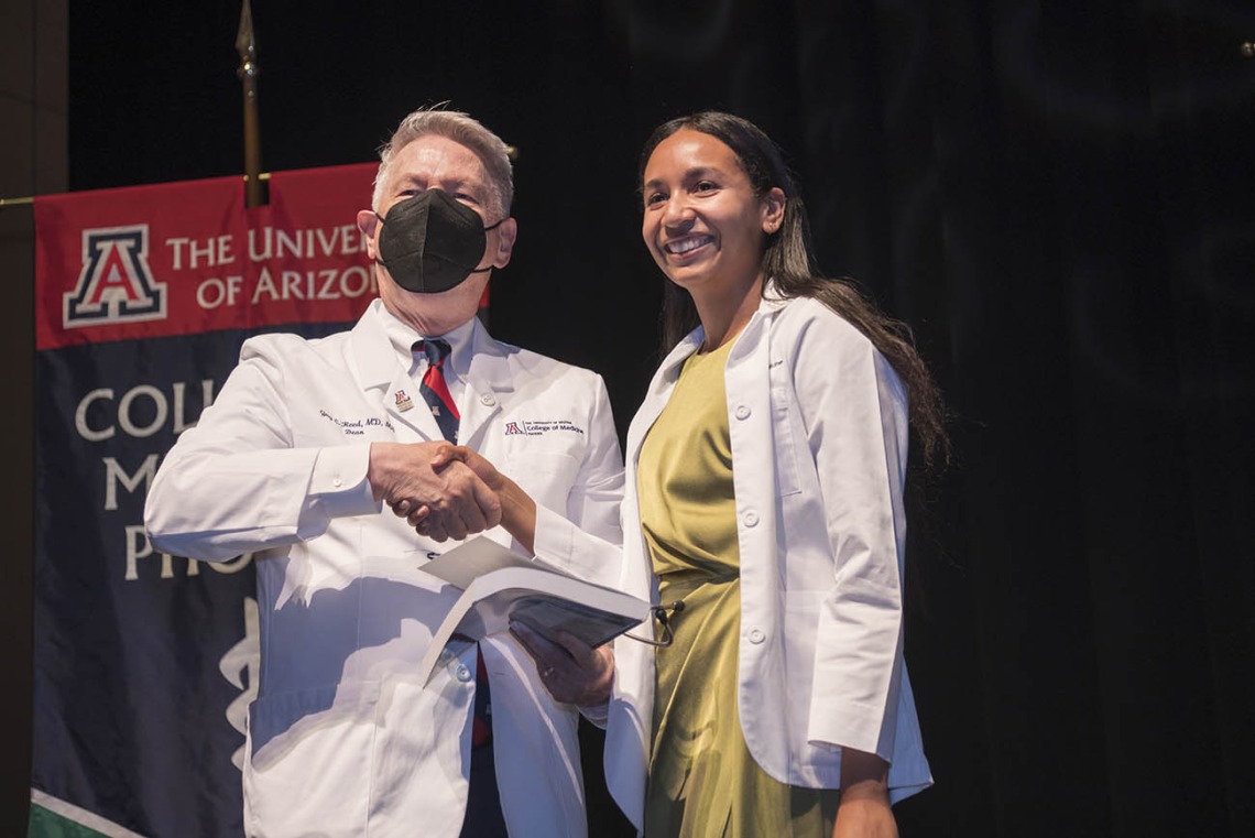 UArizona College of Medicine – Phoenix Dean Guy L. Reed, MD, MS, congratulates Santana Solomon after she received her white coat at the college’s Class of 2026 white coat ceremony.