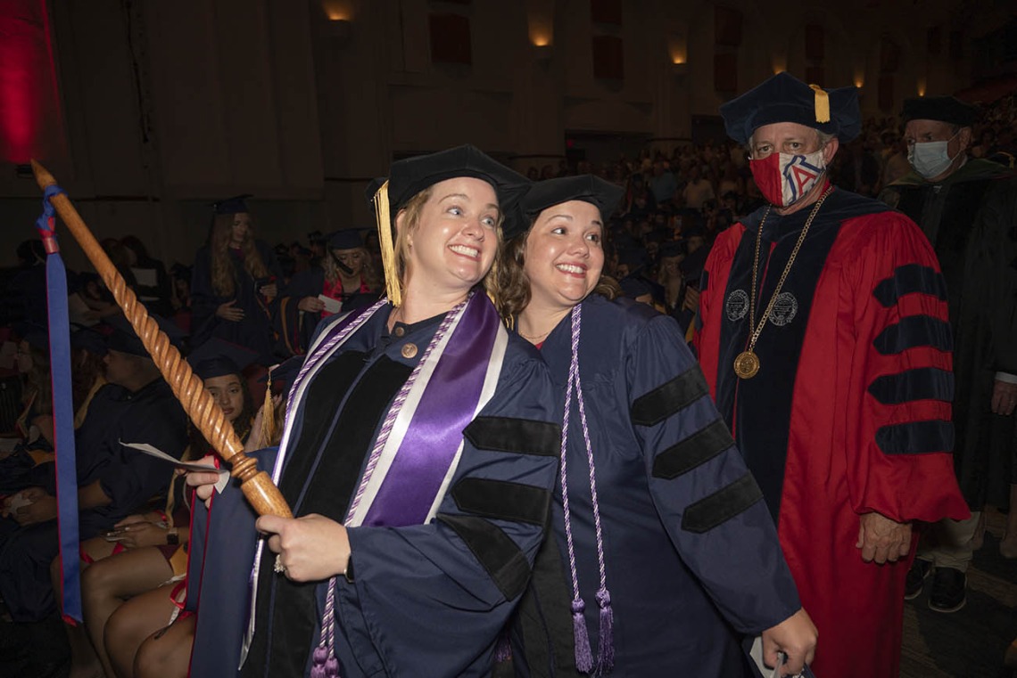 Christine Platt, who earned her Doctor of Philosophy in Nursing and Doctor of Nursing Practice, and Sally Martens, who earned her Doctor of Philosophy in Nursing, pause for a photo as they walk into Centennial Hall during the College of Nursing 2022 summer convocation.