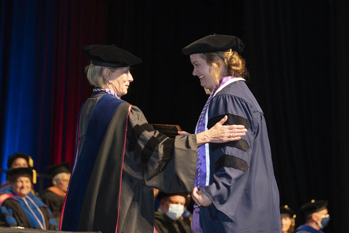 College of Nursing interim Dean Kathleen Insel, PhD, presents Christine Platt with an award for outstanding PhD-DNP candidate during the college’s 2022 summer convocation.