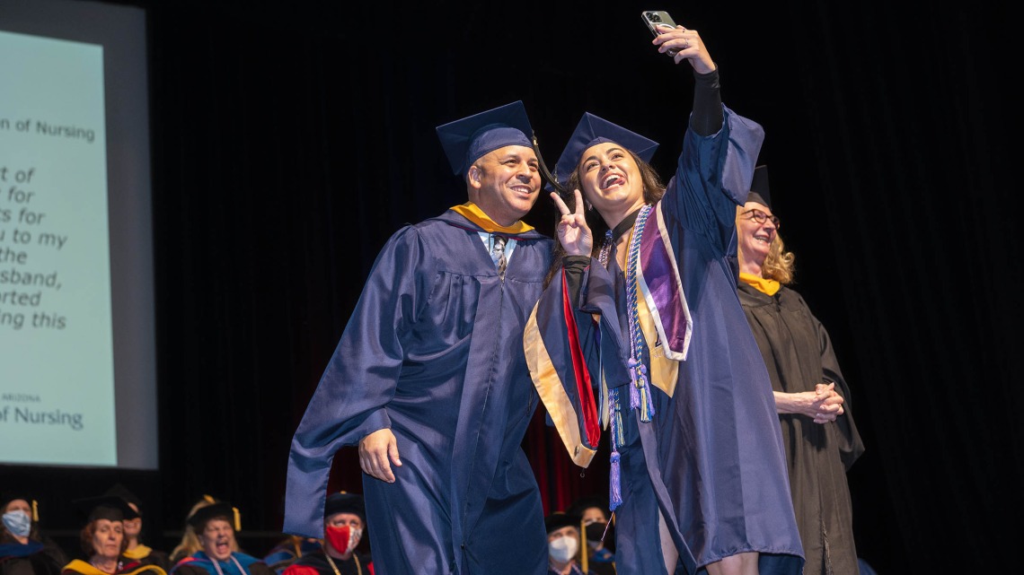 Samantha Galvez, who received her Master of Science in Nursing Entry to the Profession degree, takes a selfie with University of Arizona College of Nursing lecturer John Fraleigh, MSN, CFRN, before being hooded at the college’s summer convocation ceremony Aug. 11 at Centennial Hall.