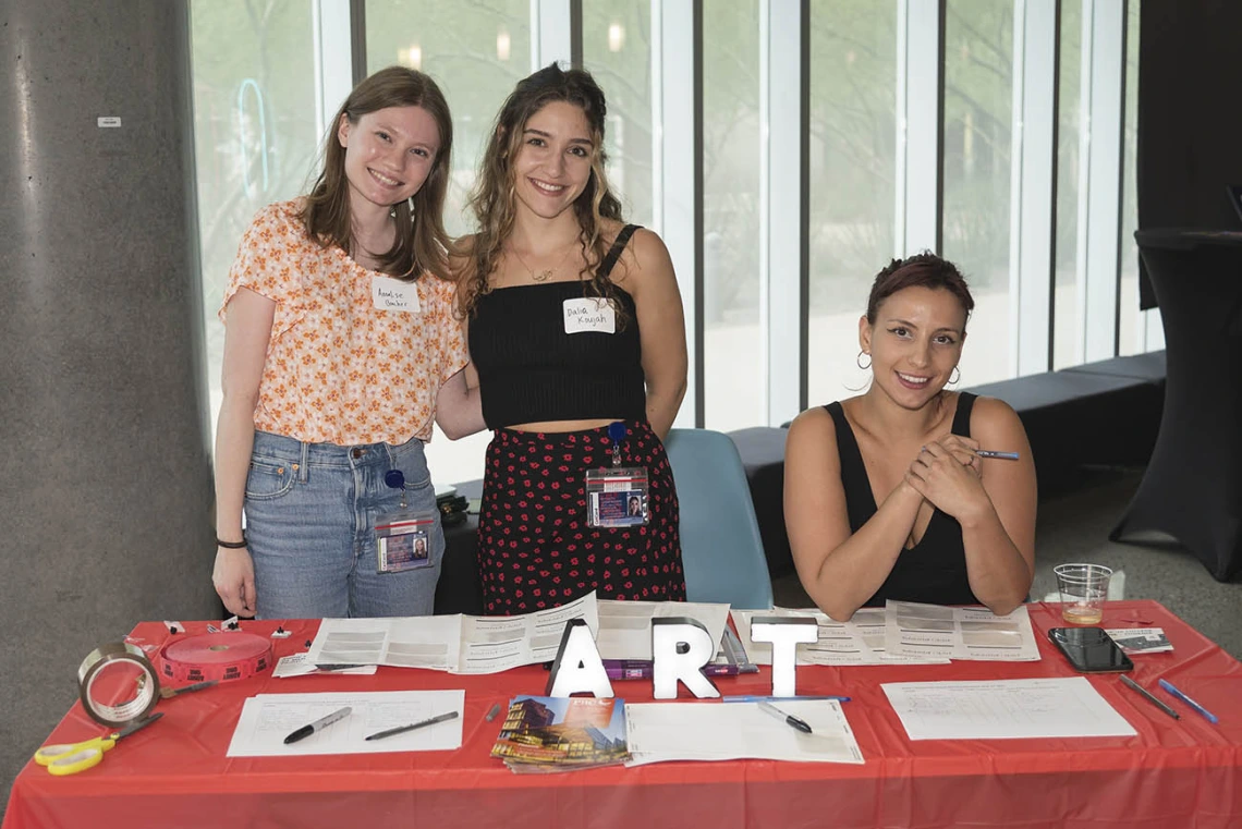 (From left) Annalise Bracher, Dalia Koujah and Maeliss Gelas, medical students in the College of Medicine – Phoenix, welcome visitors to the public opening of the Artist + Researcher exhibition inside the Health Sciences Education Building.