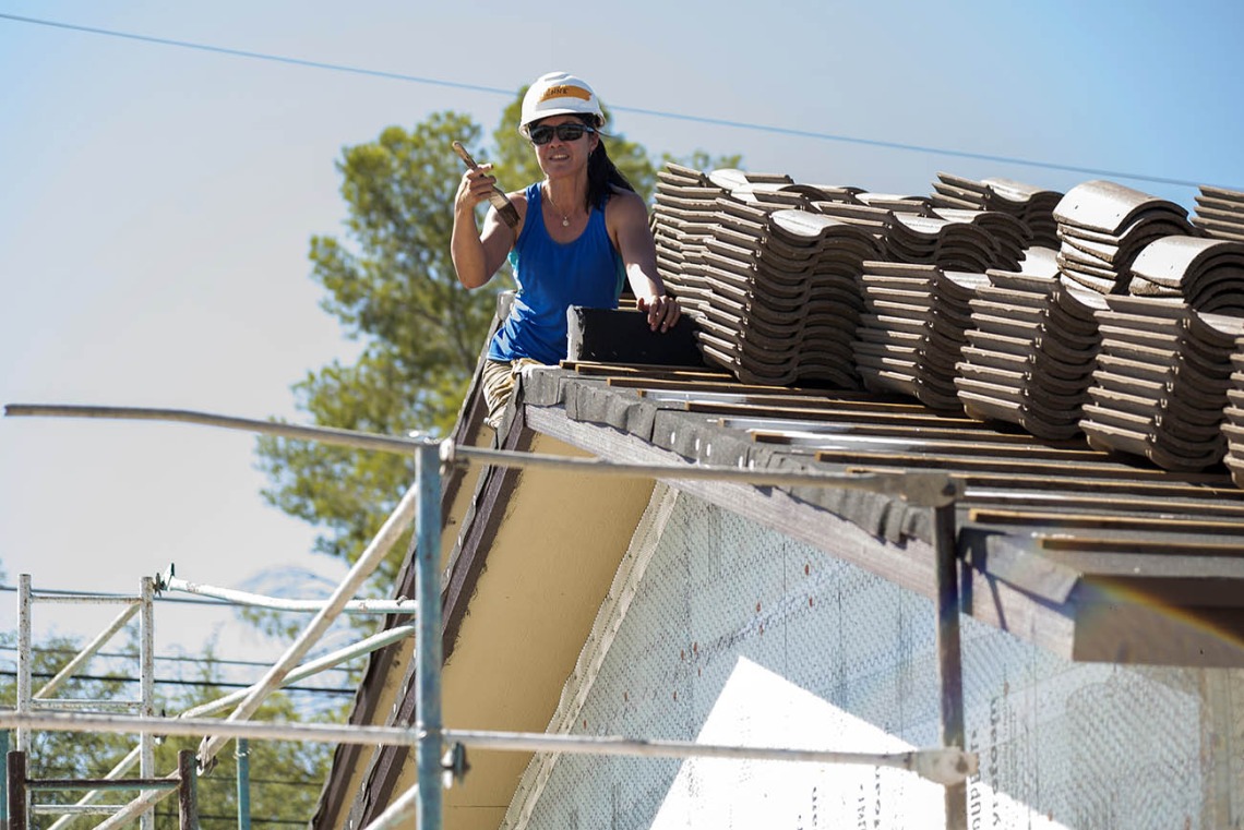 Vivienne Ng, MD, MPH, an assistant professor in the College of Medicine – Tucson’s Department of Emergency Medicine, paints the eaves on a house being built by Habitat for Humanity Tucson during the EM Day of Service.
