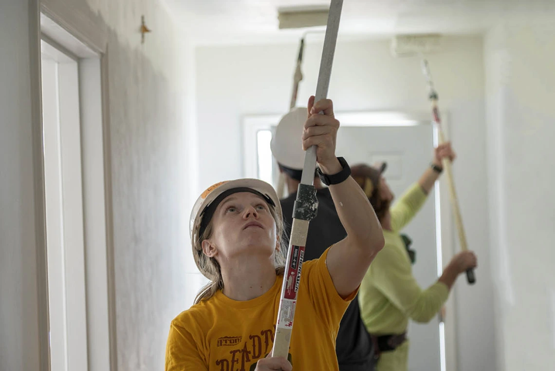 Lindsey Vandergrift, MD, a first-year emergency medicine resident at Banner – University Medical Center Tucson, paints a hallway ceiling in a new Habitat for Humanity Tucson home during the EM Day of Service.