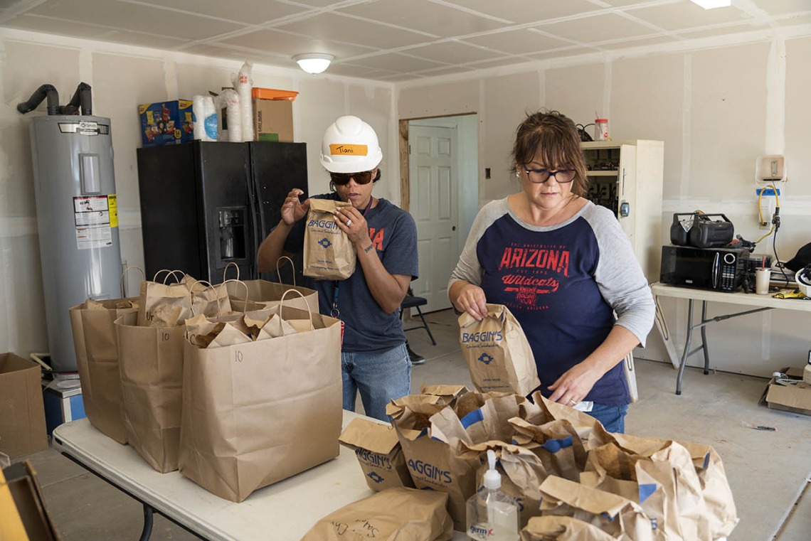 (From left) Tiani Wright, an administrative assistant, and Veronica Calderon, a senior program manager, both from the College of Medicine – Tucson’s Department of Emergency Medicine, organize lunches for EM Day of Service volunteers. 