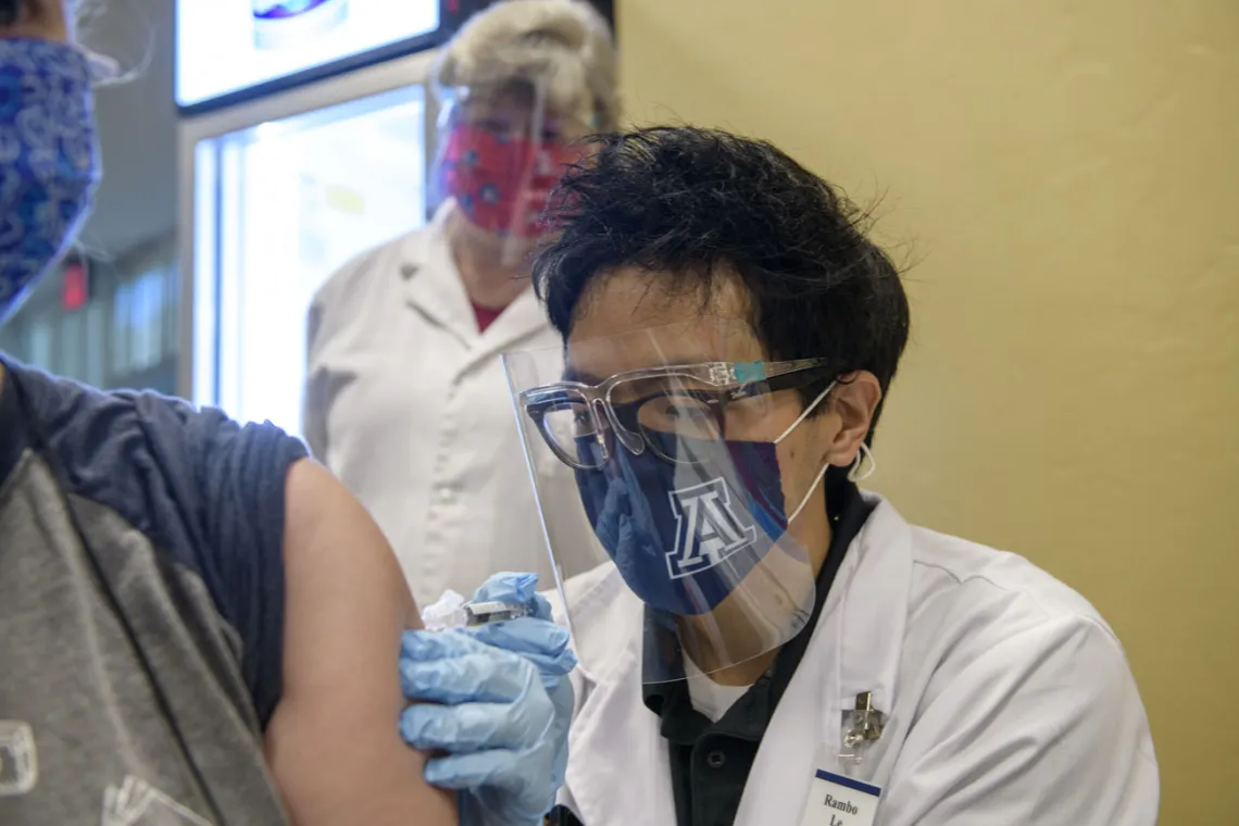 PharmD student Rambo Le administers a flu shot as preceptor Deborah Van Sant, PharmD, observes from behind him. “The flu is a lot worse than getting the flu shot,” he says, encouraging everyone to get immunized this season.