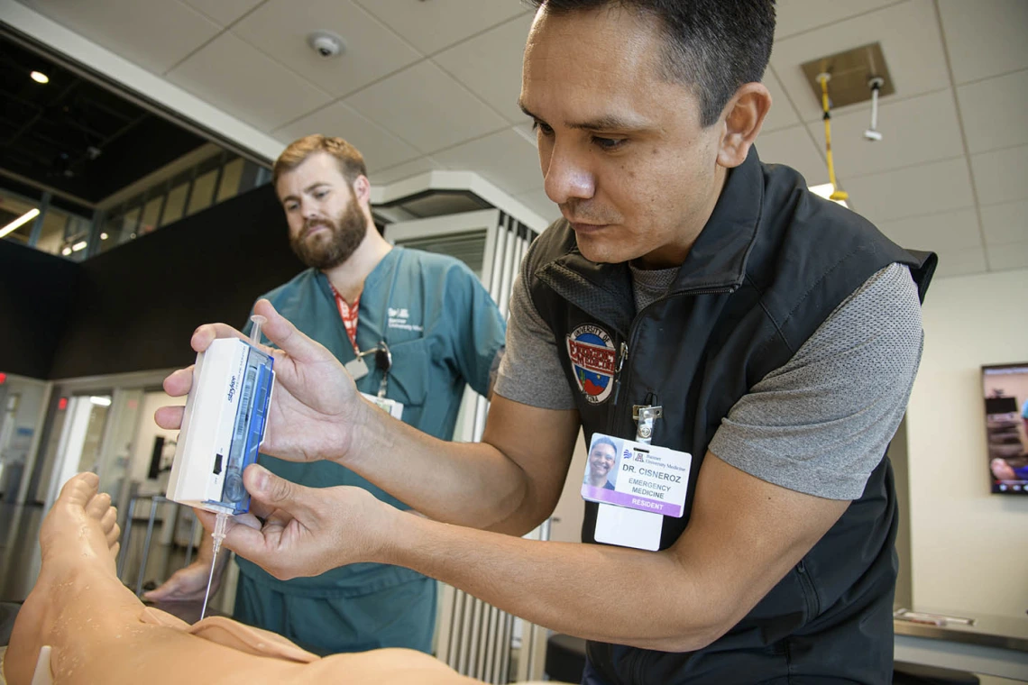 ASTEC’s SimDeck is a two-story soundstage and training environment with multiple reconfigurable rooms where health care providers, such as this emergency medicine resident, can practice medical procedures in simulated environments.