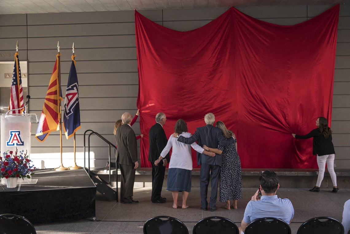 UArizona President Dr. Robert C. Robbins, College of Pharmacy Dean Dr. Rick G. Schnellmann, R. Ken Coit and his family watch the unveiling of the newely named R. Ken Coit College of Pharmacy.
