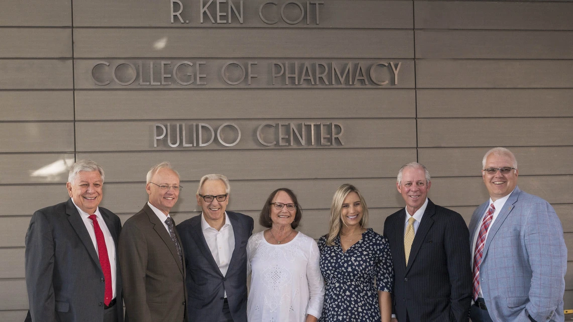 Arizona Board of Regents' Ron Shoopman, College of Pharmacy Dean Dr. Rick G. Schnellmann, R. Ken Coit, Donna Coit, Lauryn Coit Ackley, UArizona President Dr. Robert C. Robbins and UArizona Foundation President and CEO JP Roczniak stand in front of the just-unveiled R. Ken Coit College of Pharmacy signage after the announcement of a $50 million gift from the Coit Family Foundation. 