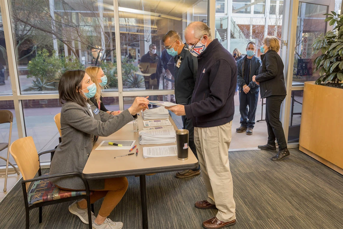 At a University of Arizona Campus Health vaccine distribution site, people walk in for their appointment to be vaccinated. 