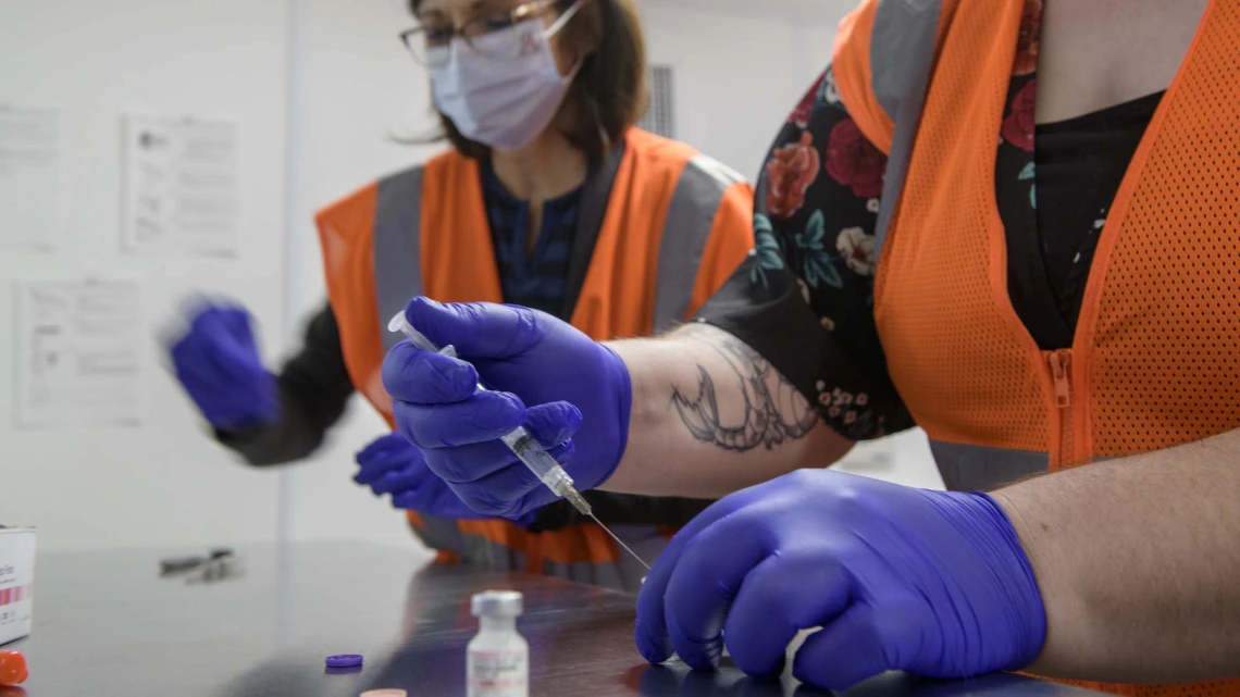 UArizona Campus Health registered pharmacist Elizabeth Preble (left) and fourth-year College of Pharmacy student Annie Hiller prepare to mix the Pfizer vaccine with saline.