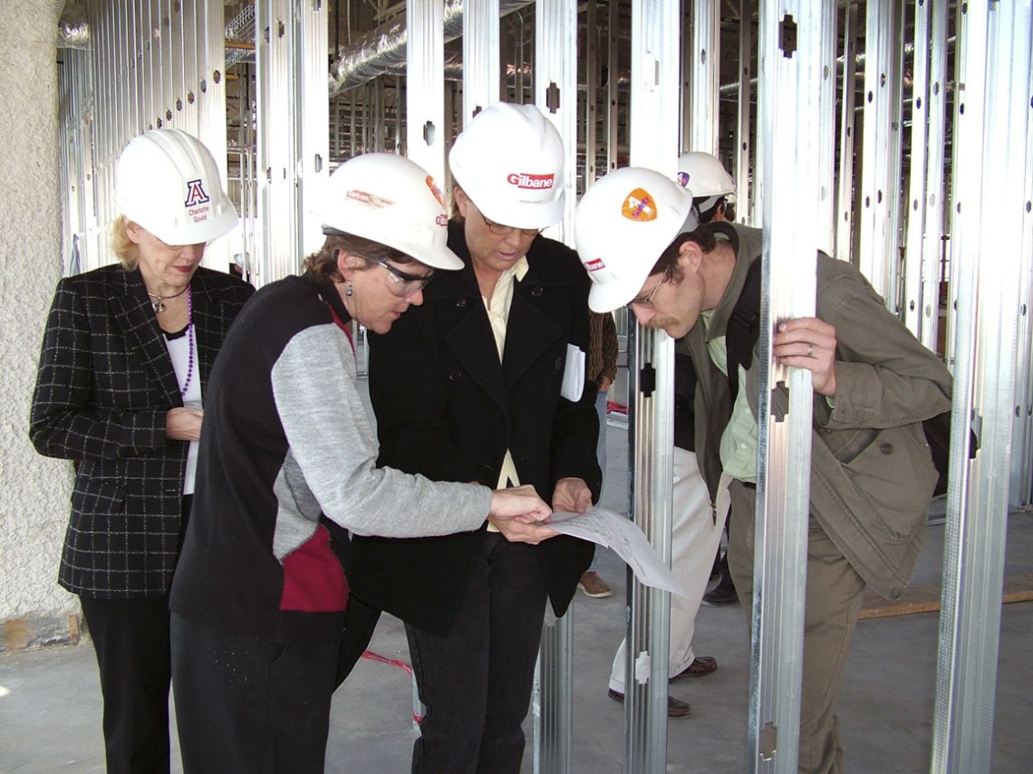 Faculty and staff inspect blueprints on their tour of Roy P. Drachman Hall, 2005. Pictured from left: Chris Tisch; Denise Roe, DrPH; Linda Temellie; Jim Ranger-Moore.