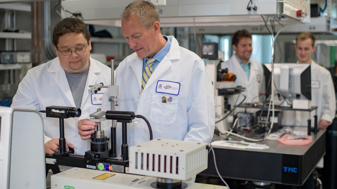 In this 2017 photo, Frederic Zenhausern, PhD, MBA, right, director of the Center for Applied NanoBioscience and Medicine, works with Matthew Barrett, a senior research specialist.