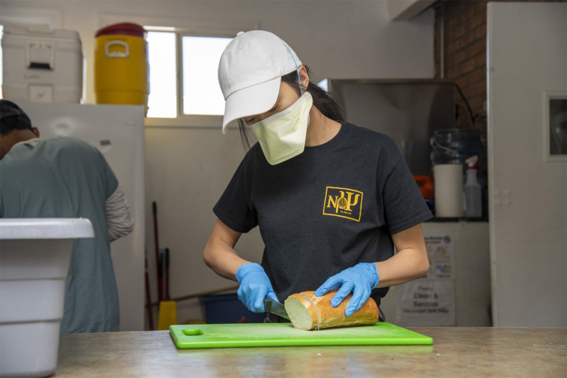Koustubh Kandapalli slices bread to prepare meals to distribute to Tucson’s homeless population. The medical student is volunteering to serve the vulnerable population during the COVID-19 pandemic.