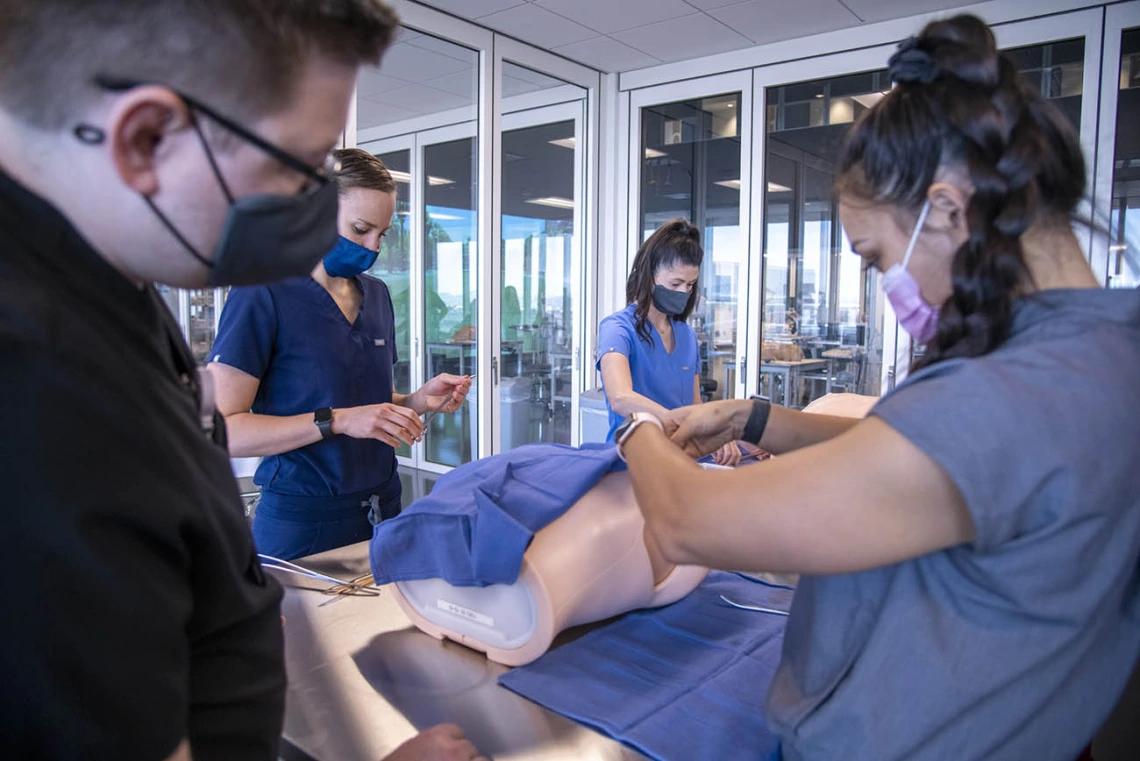 Jaron Allen Hubele, left, and Katie Pon Rambo practice thoracentesis – a procedure where a needle is inserted through the chest wall to remove fluid or air from around the lungs.  