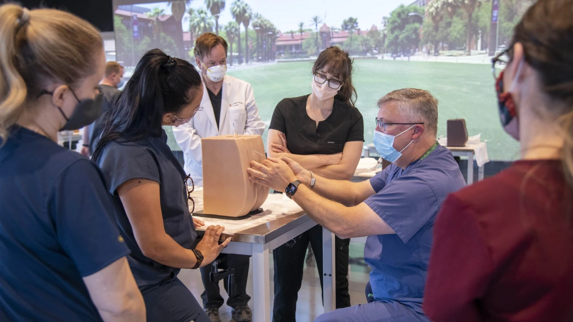 Chris Herring, DNP, CRNA, demonstrates lumbar puncture techniques to Adult-Gerontology Acute Care Nurse Practitioner (AGACNP) students at ASTEC. The ACAGNP clinicians use this technique to collect samples of cerebral spinal fluid  to assist in the diagnosis of diseases of   the neurological system.