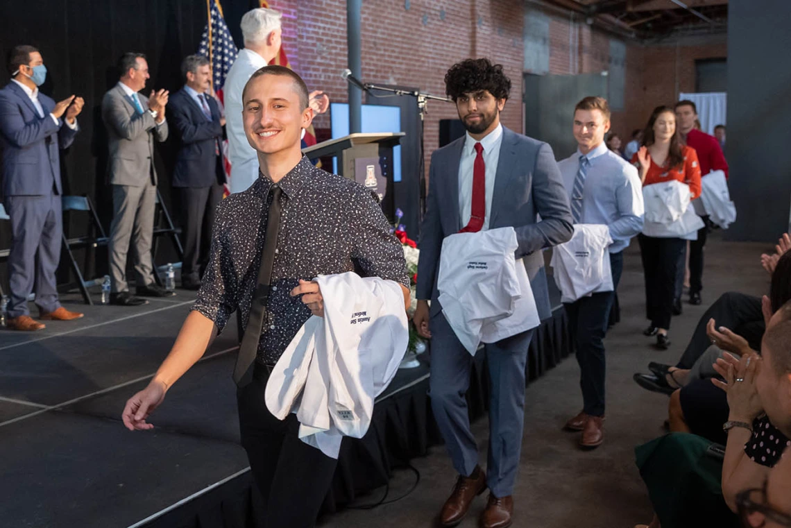 Austin Sherwood, Gurkaran Singh, Jack Stearns, Paige Steffen and Jake Stenzel cross in front of the stage on the way to their seats at the beginning of the ceremony.