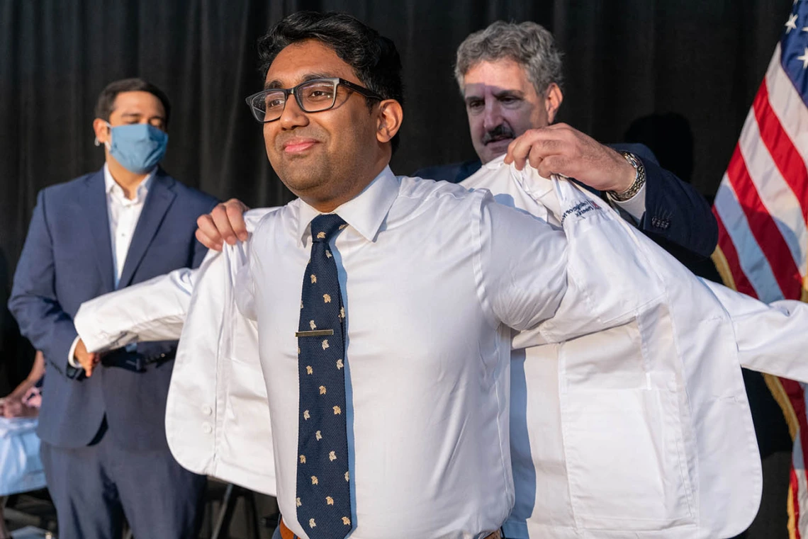 Tahmid Ahmed receives his white coat from Steven Leiberman, MD.