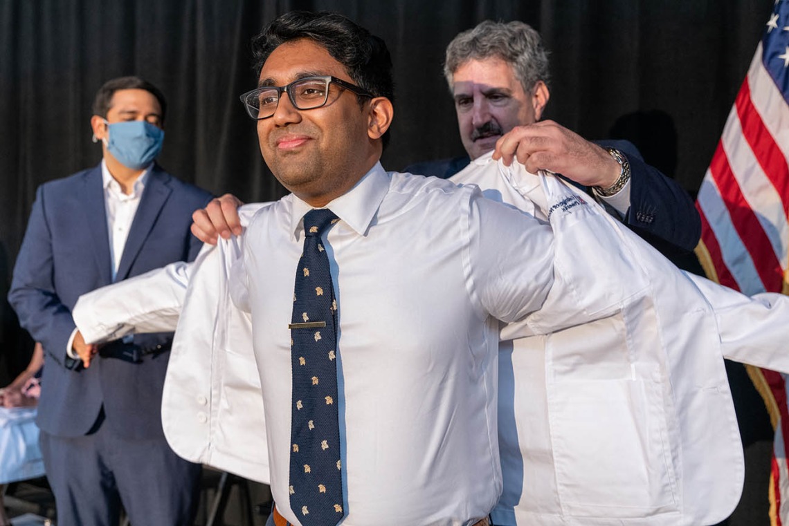 Tahmid Ahmed receives his white coat from Steven Leiberman, MD.