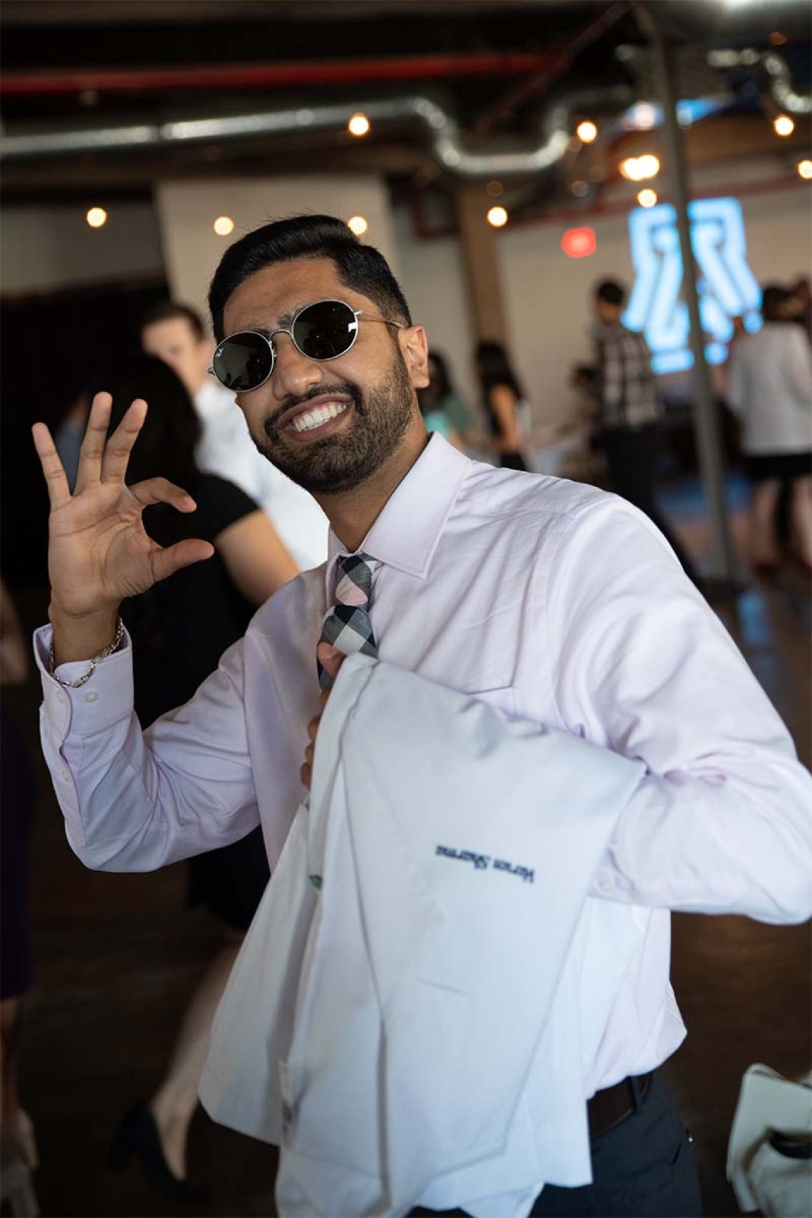 Varun Sharma pauses to give the Wildcat sign before the Class of 2024 white coat ceremony begins.
