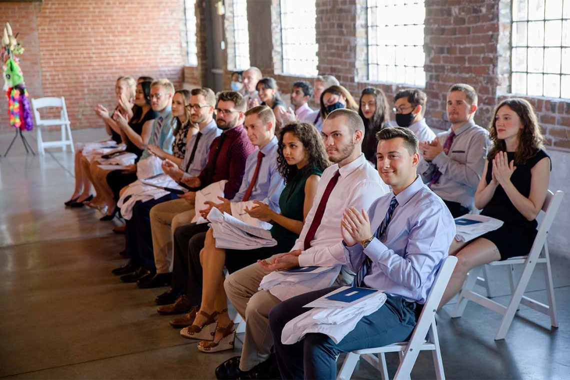 Second-year med students applaud a speaker at their long-anticipated white coat ceremony. 