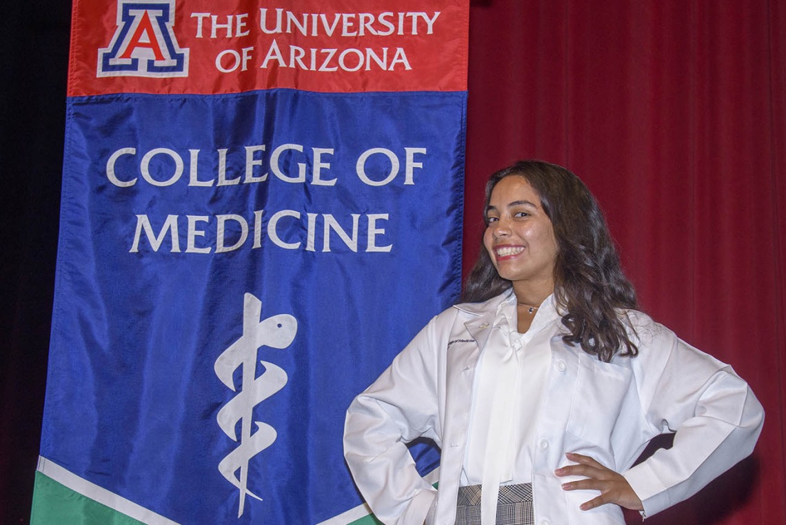 Gisselle Pegaitaz poses in front of the UArizona College of Medicine – Tucson banner after receiving her white coat. 