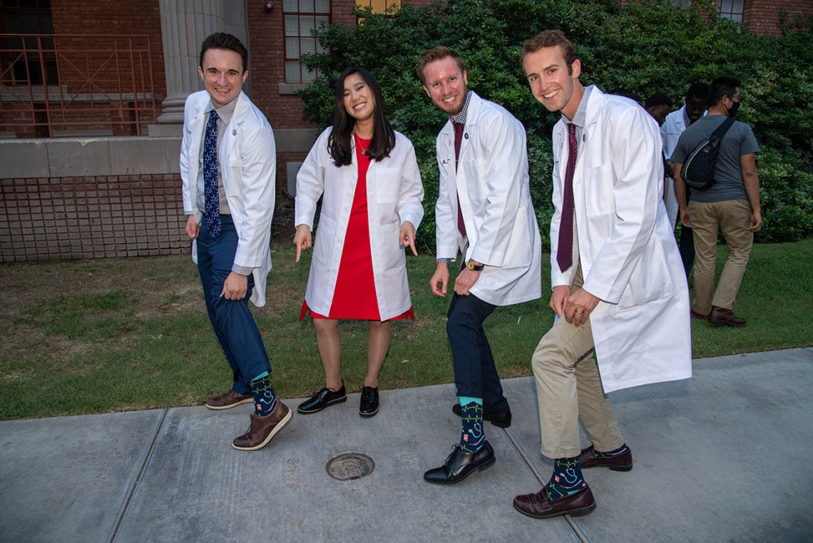 Newly “white-coated” medical students, from left, Riley Hellinger, Coco Victoria Gomez Tirambulo, Mathew Flower and Zak Webber show off their “doctor” socks. 