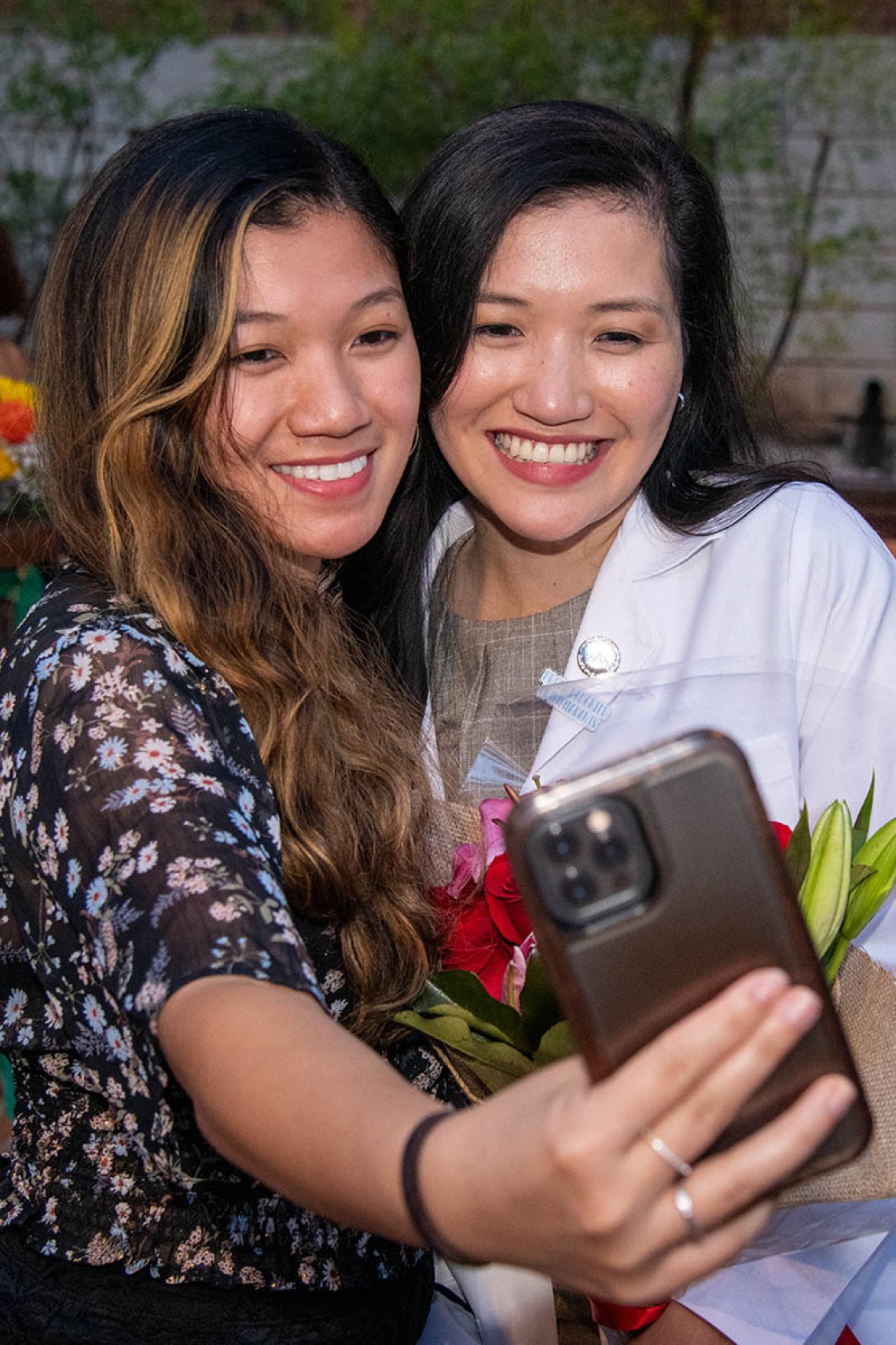 Medical student Bobbie Alcanzo takes a selfie with her sister Bernice Alcanzo after the Class of 2025 white coat ceremony.