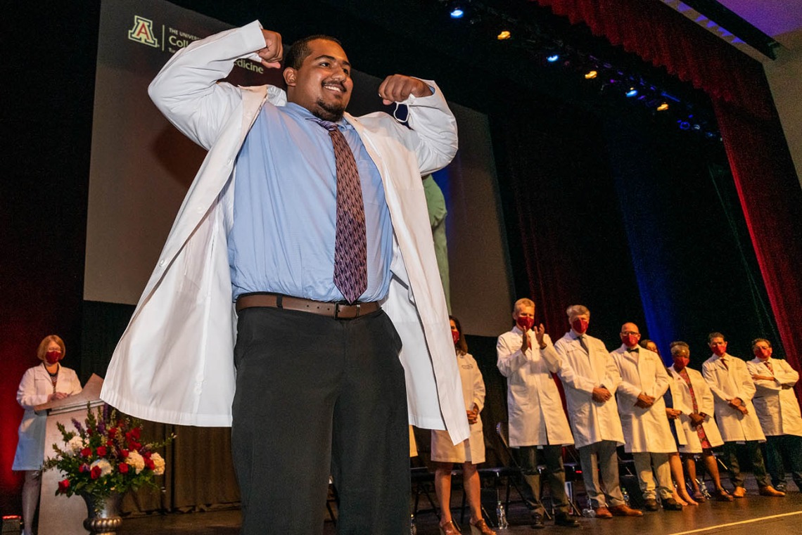 D'Andre Gomez gives a flex to the crowd after being presented his white coat by Dr. Puneet Schroff. 