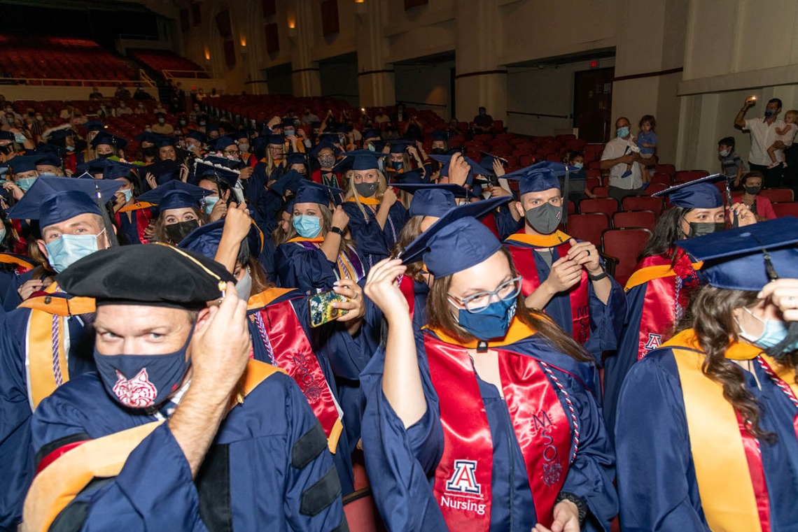 Graduates turn their tassels at the conclusion of the  August commencement at Centennial Hall.
