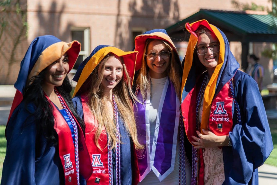 Freshly hooded graduates from the August commencement pose for a photo.